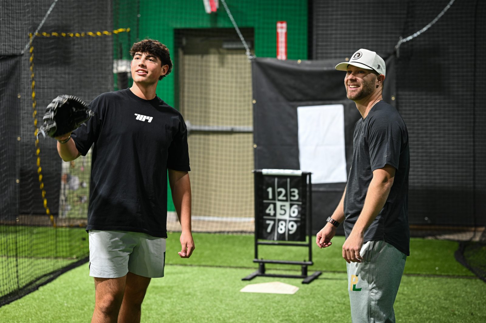 Coach Cody Stull working with an athlete beside the target during an assessment at The Pitch Lab