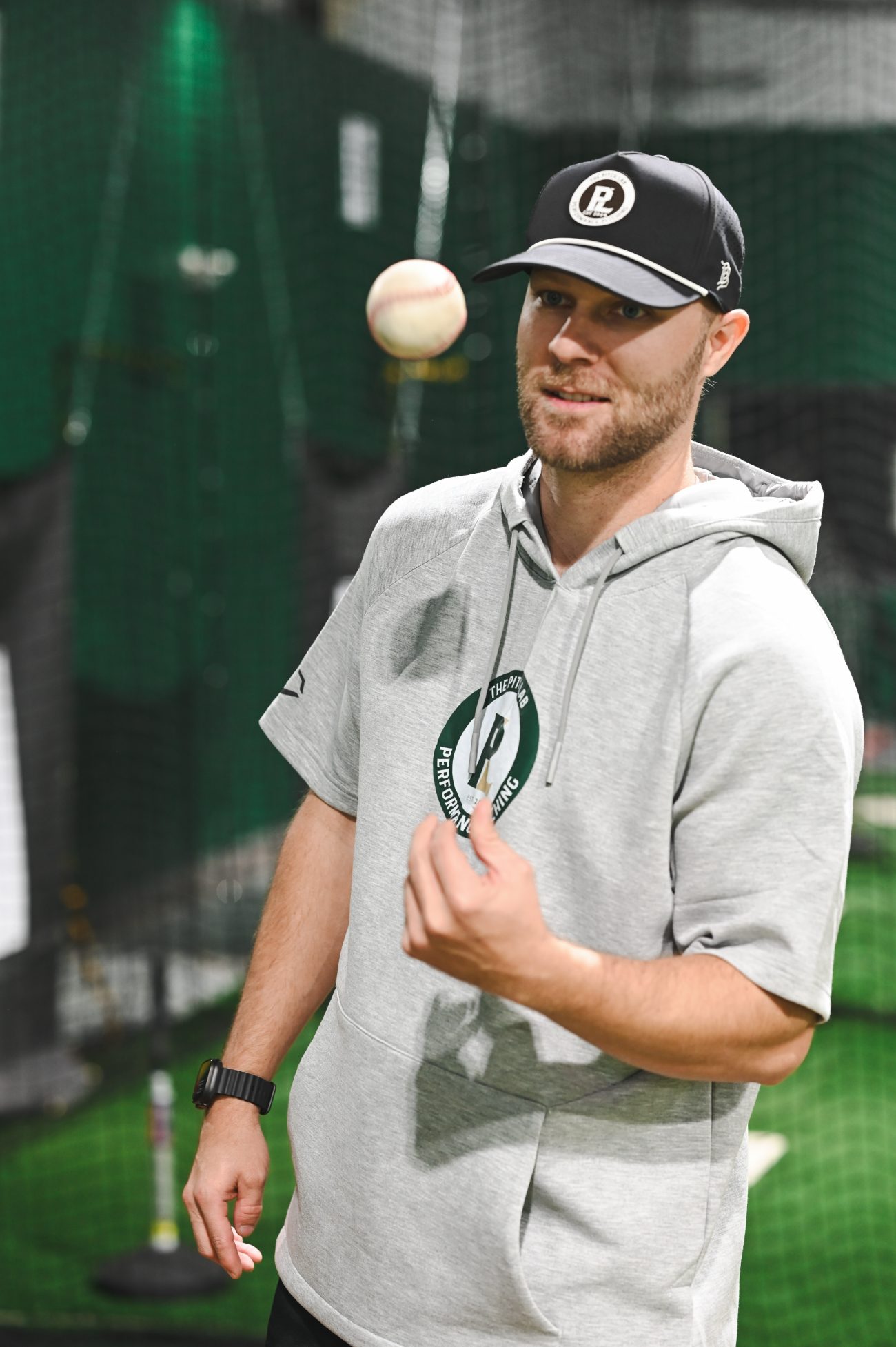 Coach Cody Stull flipping a baseball in The Pitch Lab training facility